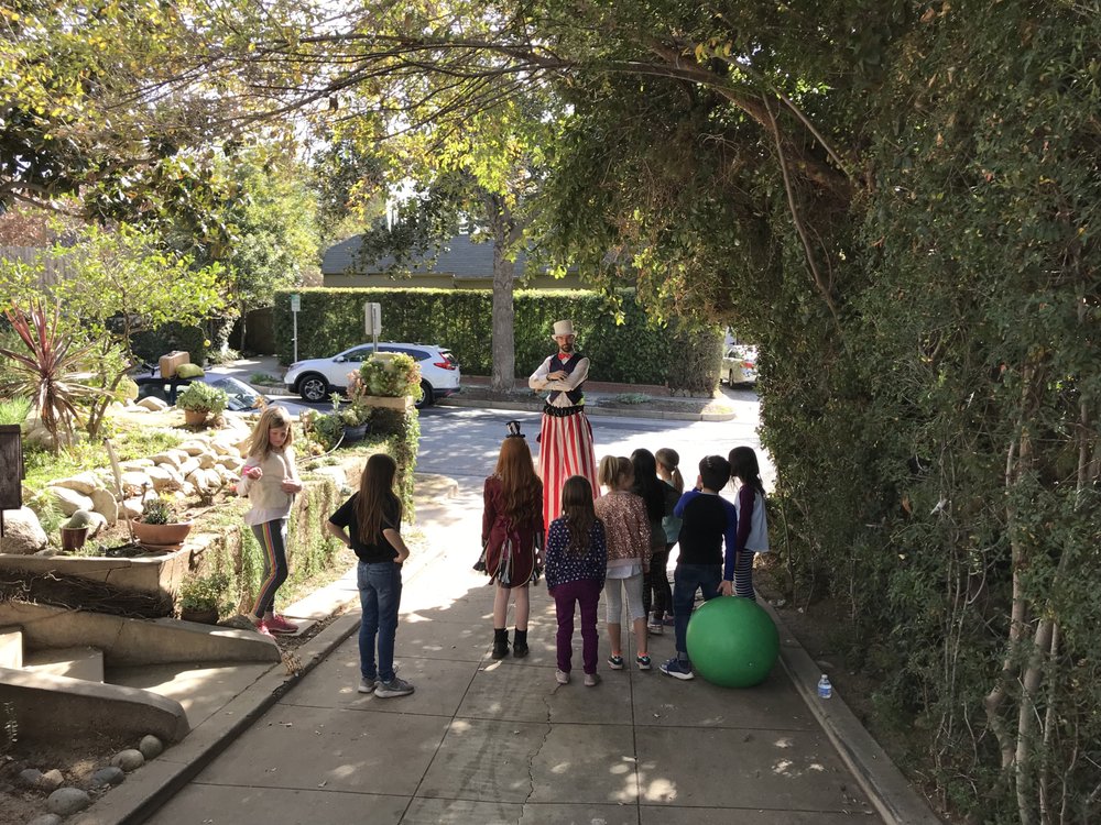 Nick entertaining children outdoors while walking on stilts